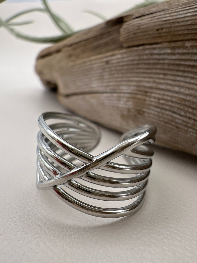 Silver ring on a textured surface with a blurred background