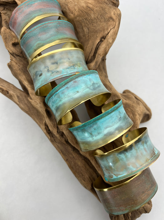 a collection of beautiful turquoise patina bracelets on a wooden display