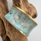 turquoise patina bracelet on a wooden display