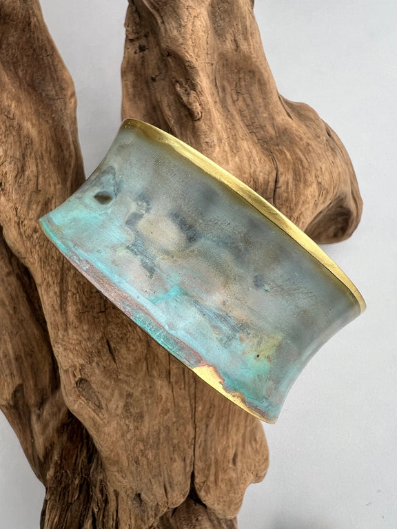 turquoise patina bracelet on a wooden display