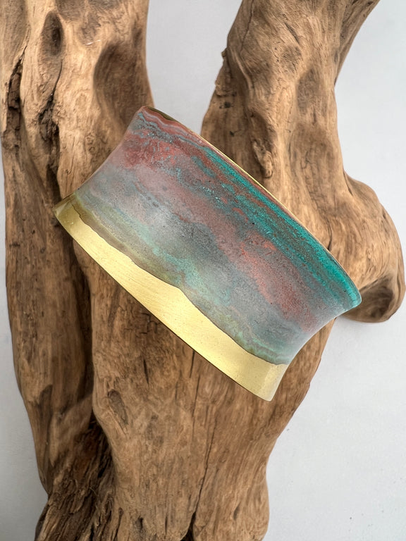 turquoise patina bracelet on a wooden display
