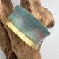 turquoise patina bracelet on a wooden display