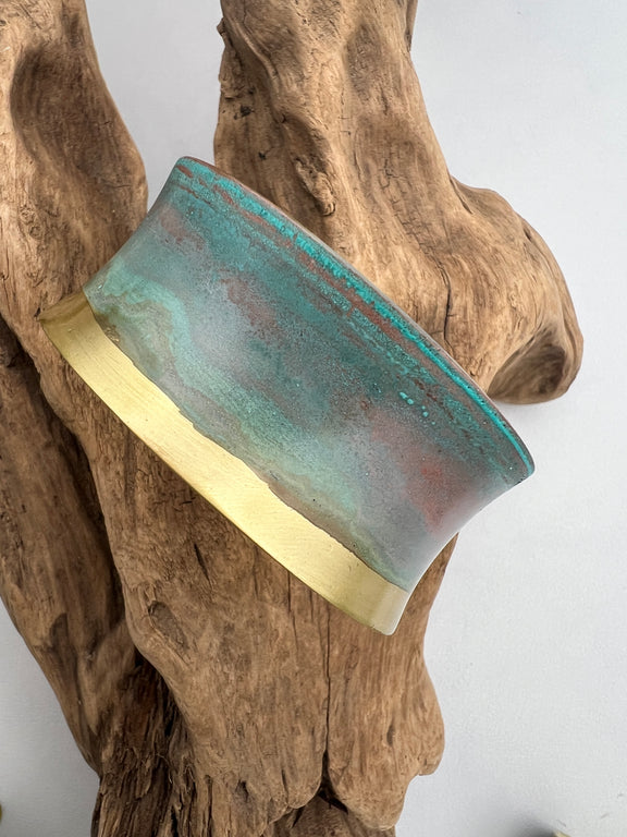 turquoise patina bracelet on a wooden display