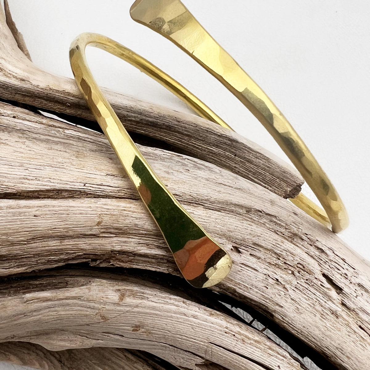 Golden hammered brass twist bracelet with an adjustable fit, designed to be waterproof and sweatproof for all-day wear.