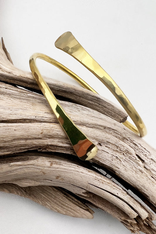 Golden hammered brass twist bracelet with an adjustable fit, designed to be waterproof and sweatproof for all-day wear.