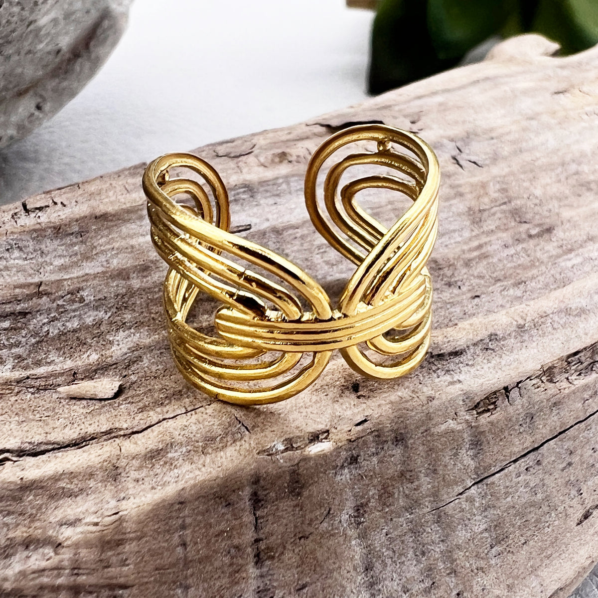 elegant golden adjustable ring on a piece of wood