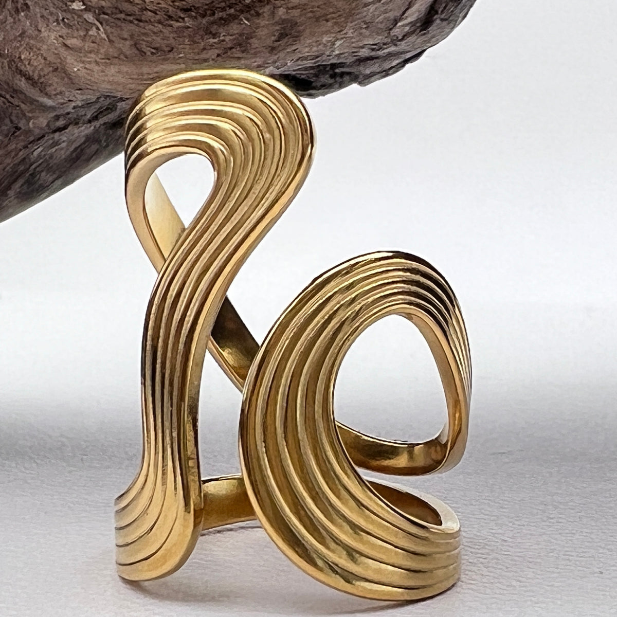 Gold abstract wave ring on a white background