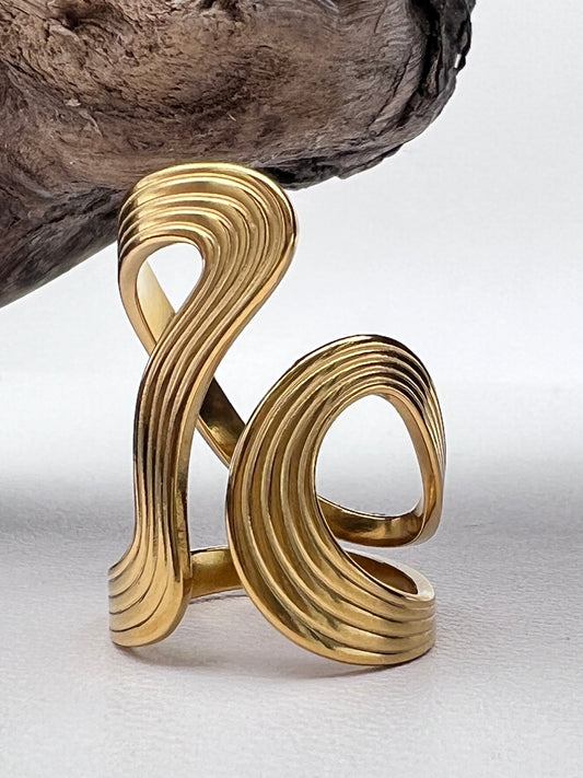 Gold abstract wave ring on a white background