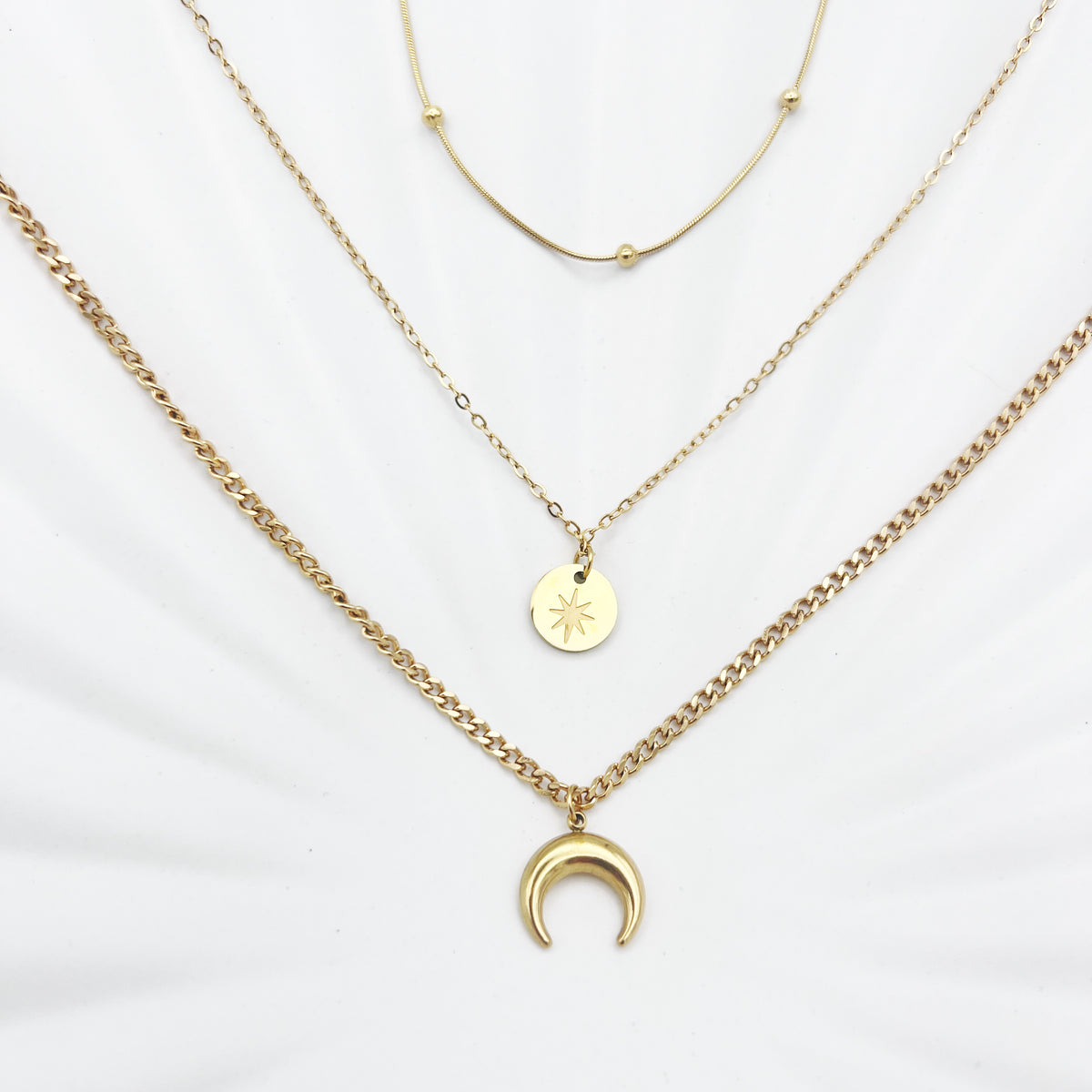 Triple-layered 14k gold-plated stainless steel necklace with a crescent moon, sun coin, and satellite chain. Waterproof and tarnish-resistant.