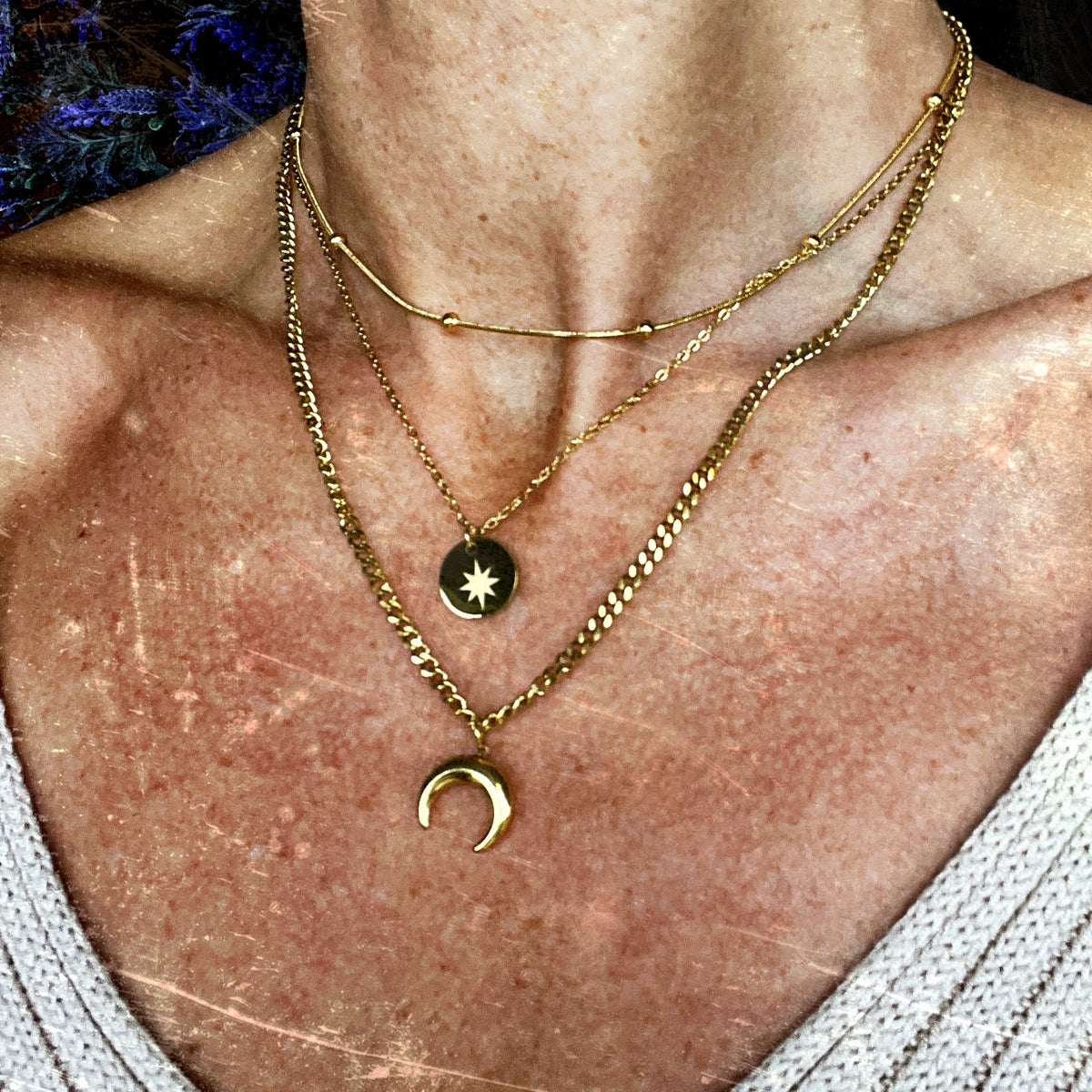 Triple-layered 14k gold-plated stainless steel necklace with a crescent moon, sun coin, and satellite chain. Waterproof and tarnish-resistant.
