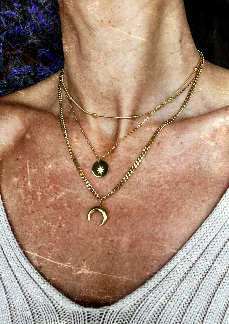 Triple-layered 14k gold-plated stainless steel necklace with a crescent moon, sun coin, and satellite chain. Waterproof and tarnish-resistant.